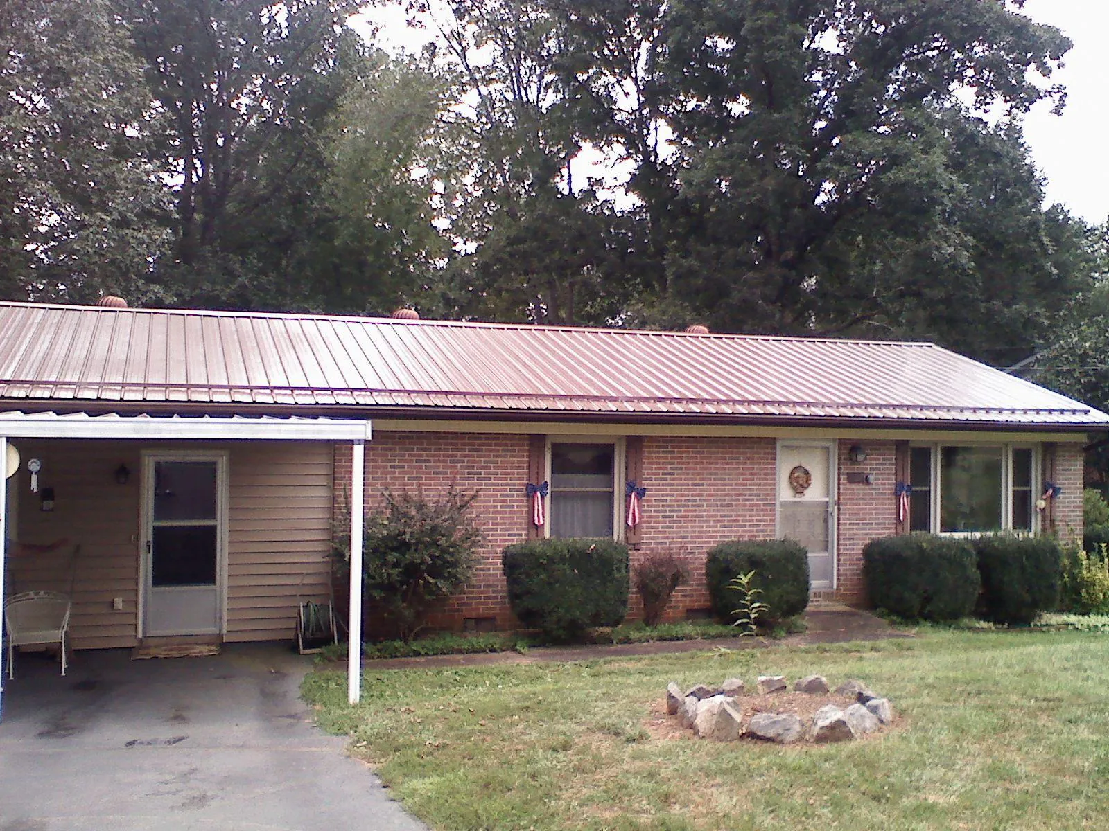 Bronze metal roof and carport on a brick ranch home — Roof Repair work by our crew in Cleaton